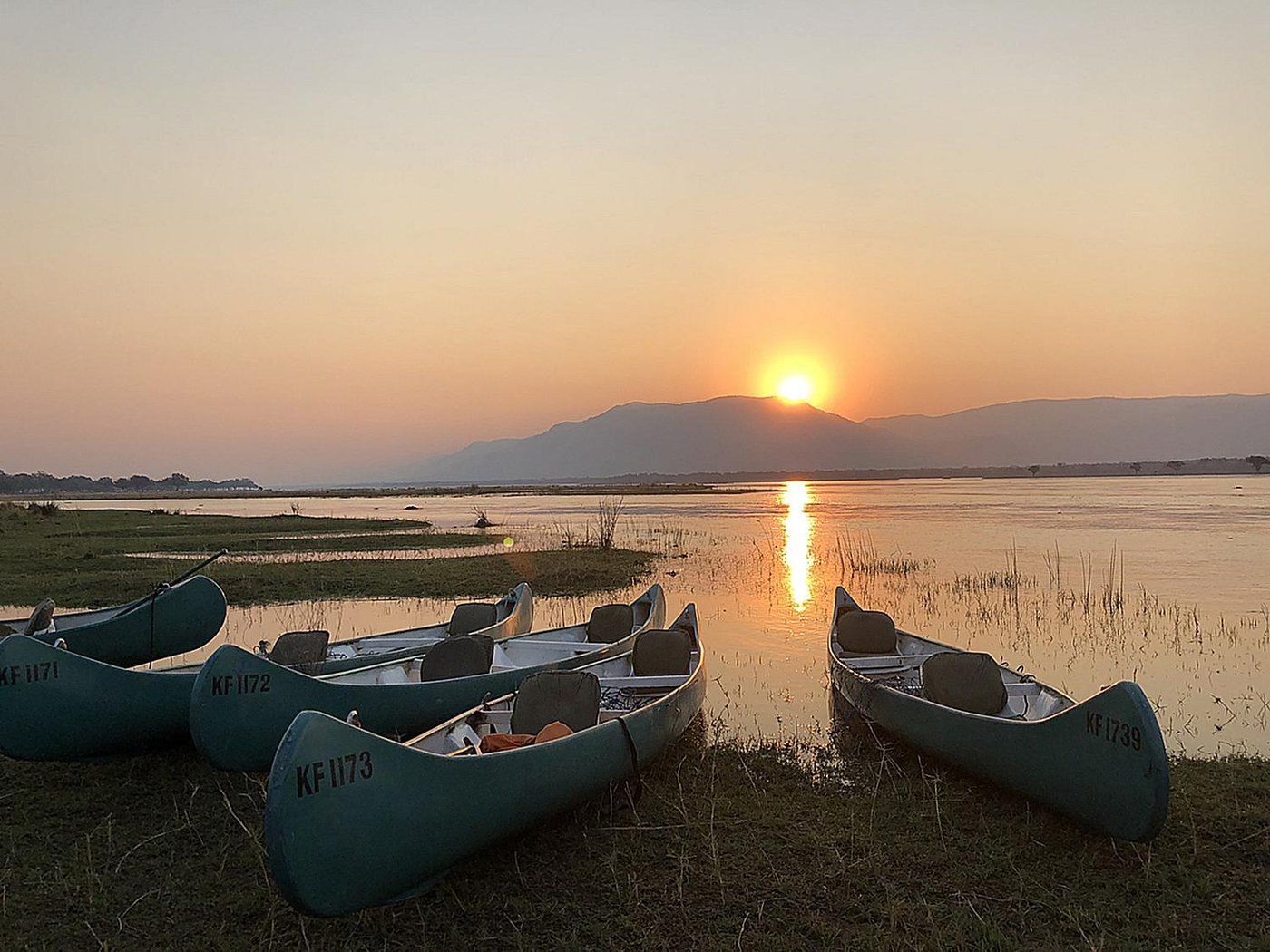 Canoes lined up on the Zambezi bank at sunset at Camp Mana.