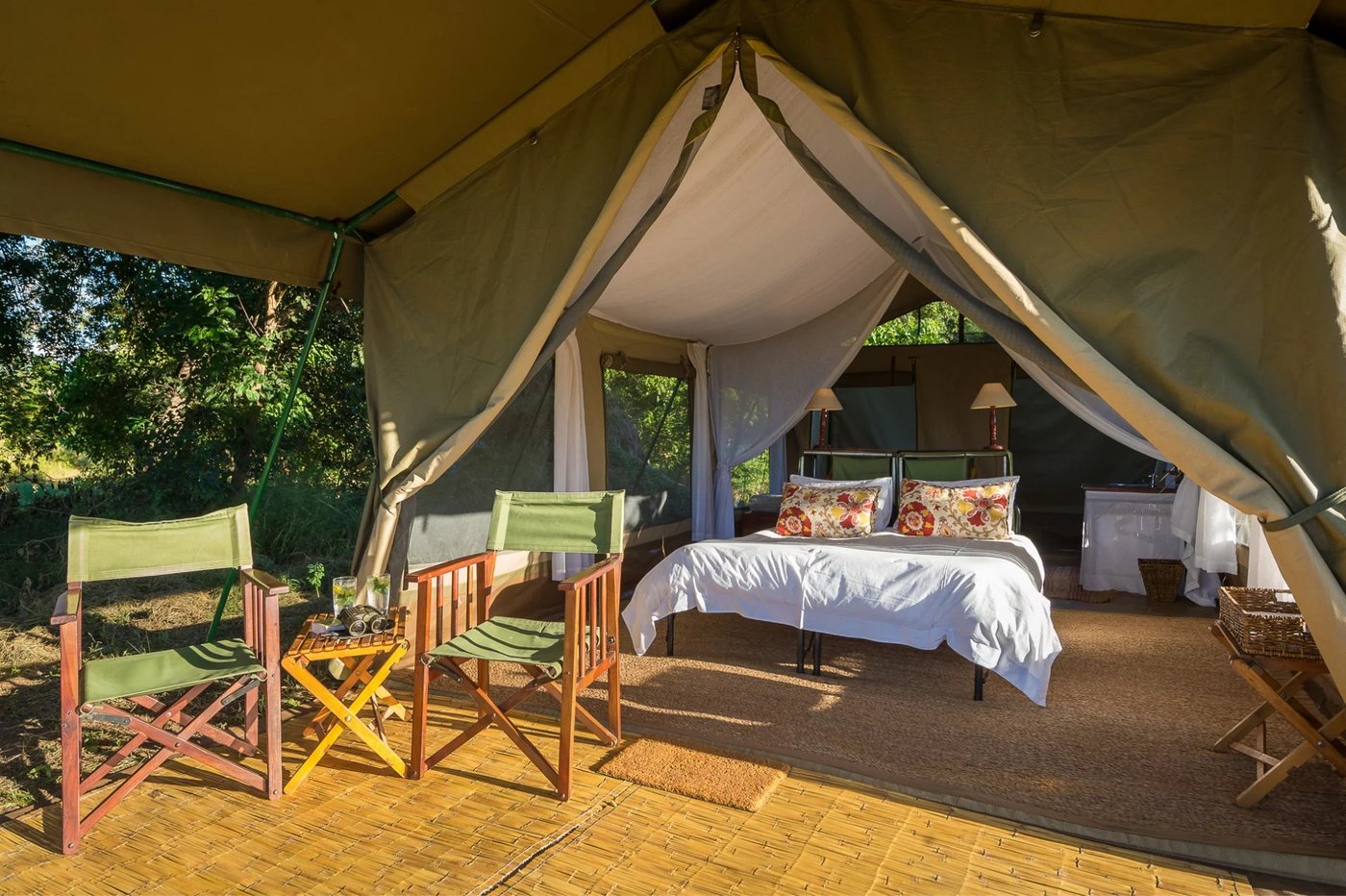 Tent bedroom with director's chairs and a canvas ceiling at John's Camp.