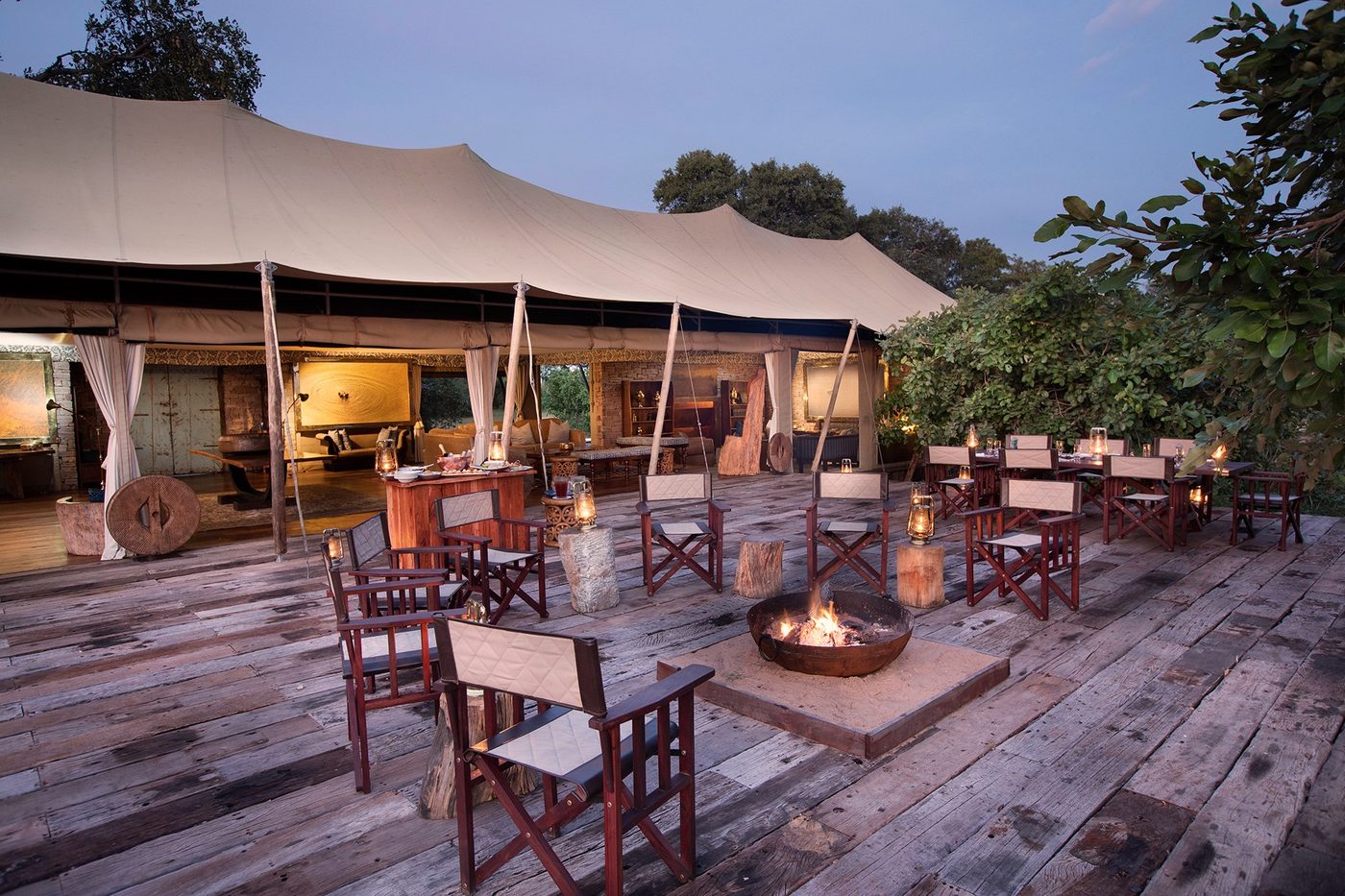 Wooden deck with fire pit and chairs at Tembo Plains Camp, Mana Pools.